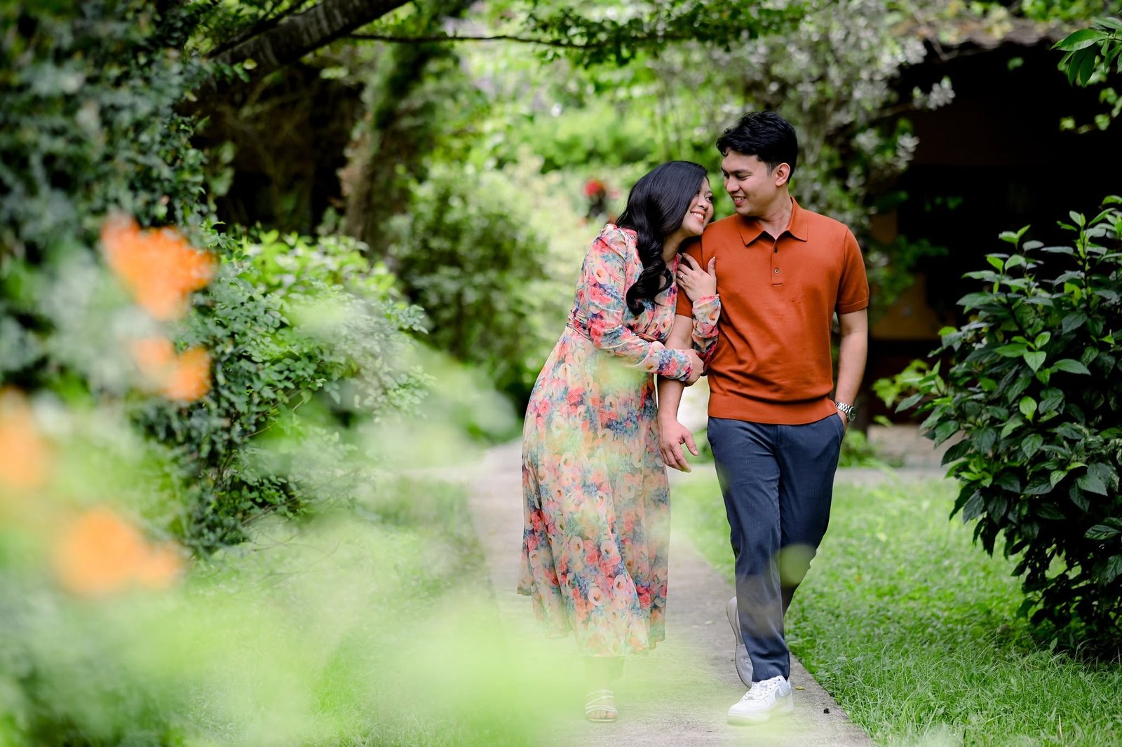 Chie and Cath walking arm in arm along a garden path.